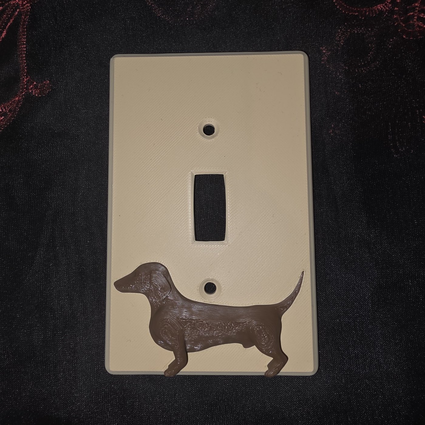 Custom 3D-printed light switch cover shaped like a dachshund dog