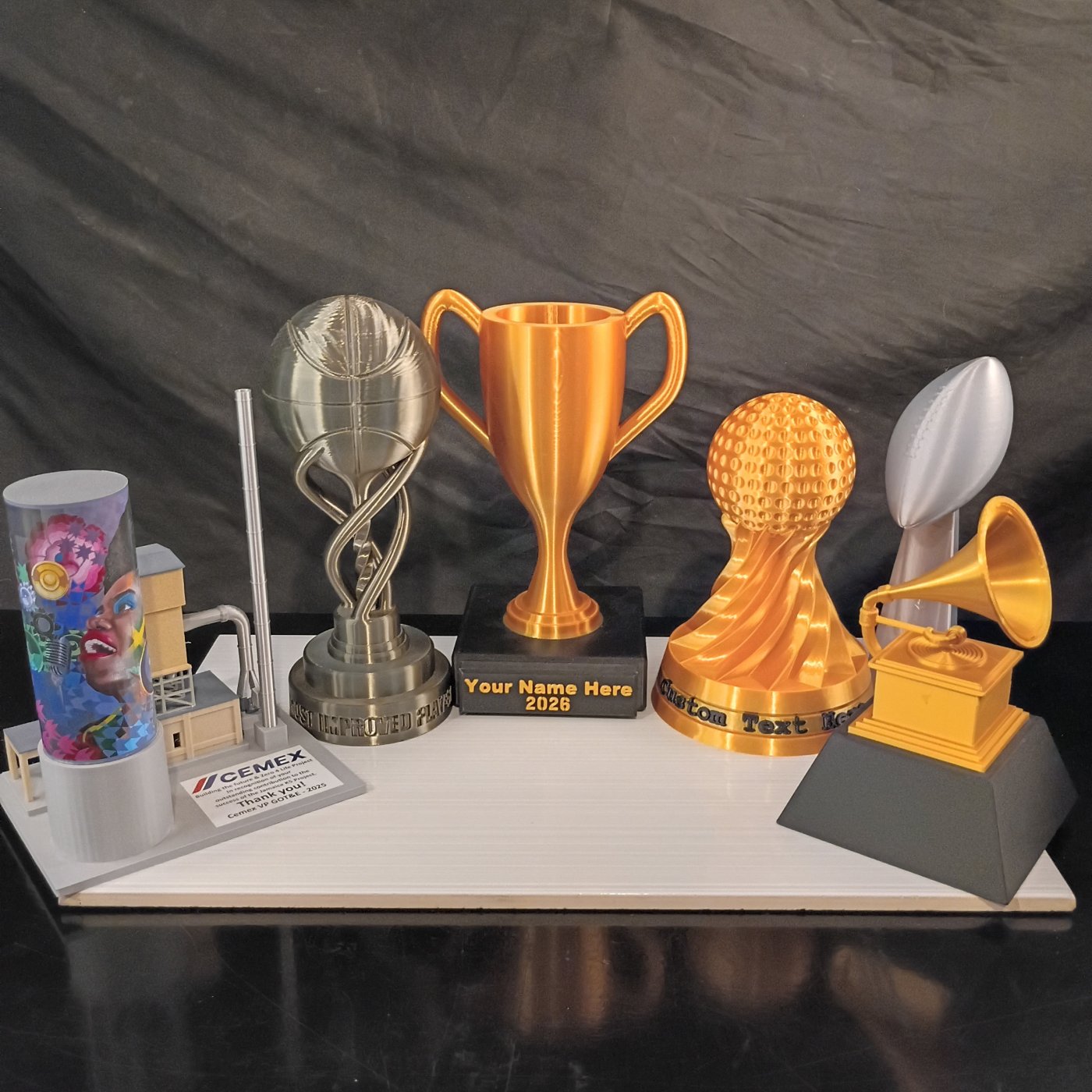 Custom 3D-printed trophies and awards, including a basketball, cup, golf, football, and Grammy-style trophy